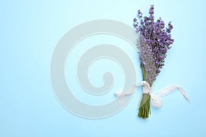 Beautiful lavender bouquet on blue background, top view. Space for text