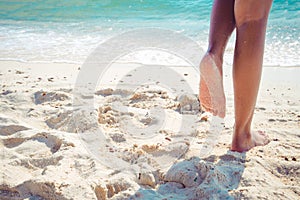 Beautiful leg of women tan. relax on sandy tropical beach.
