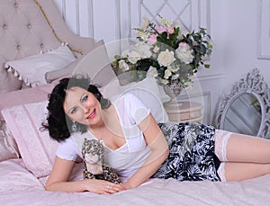 Beautiful legged brunette girl in miniskirt and white stockings posing on sofa
