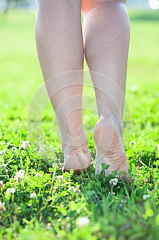 Beautiful legs stepping on green grass
