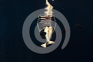 Beautiful legs woman underwater on teeter totter swing