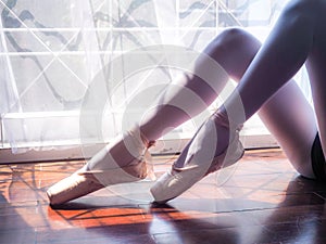 Beautiful legs of young ballerina. Ballet practice. Beautiful slim graceful feet of ballet dancer