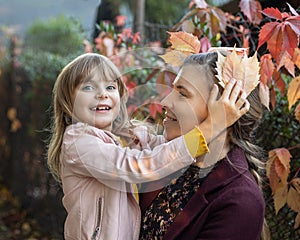 Beautiful lifestyle autumn photo of mother and child daughter walking in autumn in the Park. The concept of happy motherhood, hugs