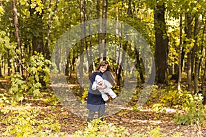 Beautiful lifestyle autumn photo mother and child walks in the park, warm sunlight