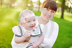 Beautiful lifestyle summer photo mother and baby girl walks in the park