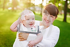 Beautiful lifestyle summer photo mother and baby girl walks in the park