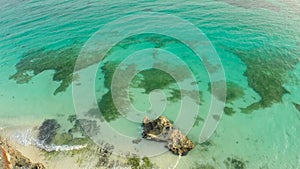 A beautiful light green coast with reefs and a loving couple on the balcony above the beach. The beautiful nature of the