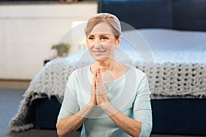 Beautiful light-haired woman having morning meditation at home