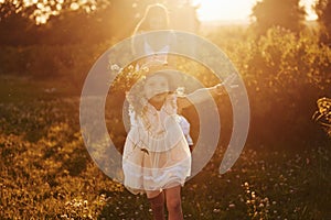 Beautiful lightbeam. Mother with boy and girl spending free time on the field at sunny day time of summer photo