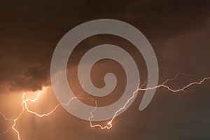 beautiful lightning during a thunderstorm at night in a forest that caused a fire, against a dark sky with rain