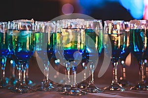 Beautiful line of different colored alcohol cocktails with smoke on a Christmas party, tequila, martini, vodka, and others on part