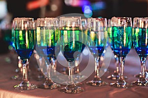 Beautiful line of different colored alcohol cocktails with smoke on a Christmas party, tequila, martini, vodka, and others on part