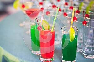 Beautiful line of different colored alcohol cocktails with smoke on a Christmas party, tequila, martini, vodka, and others on part