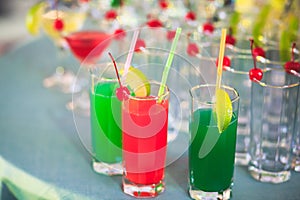 Beautiful line of different colored alcohol cocktails with smoke on a Christmas party, tequila, martini, vodka, and others on part