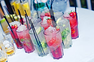 Beautiful line of different colored alcohol cocktails with smoke on a Christmas party, tequila, martini, vodka, and others on part