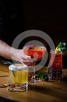 Beautiful line of three colorful alcoholic cocktails on a bar in a nightclub