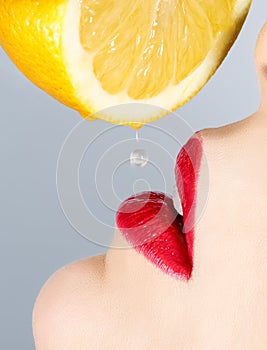 Beautiful lips and falling drop of lemon