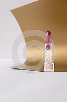 Beautiful lipstick on golden background. Professional makeup product.