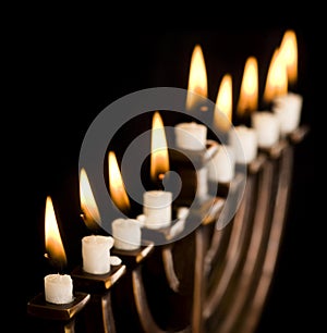 Beautiful lit hanukkah menorah on black.