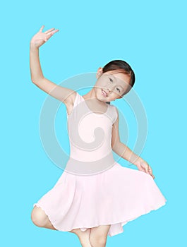 Beautiful little Asian child girl in pink tutu skirt isolated on cyan background. Children is studying ballet