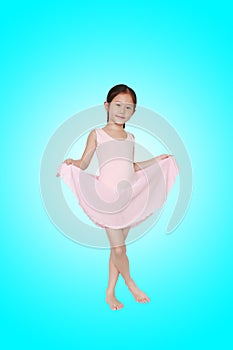 Beautiful little Asian child girl in pink tutu skirt isolated on cyan background. Children is studying ballet