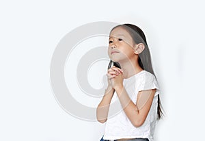 Beautiful little asian child girl praying isolated over white background with looking up. Spirituality and religion concept