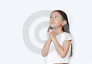 Beautiful little asian child girl praying isolated over white background with looking up. Spirituality and religion concept