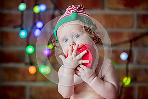 Beautiful little baby boy in elf hat with gift box