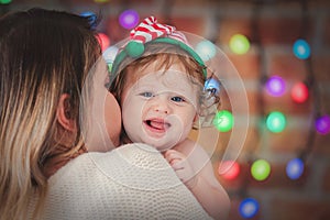 Beautiful little baby boy in elf hat and mother