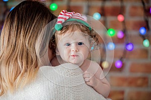Beautiful little baby boy in elf hat and mother