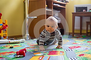 Beautiful little baby boy, toddler smiling at camera, animals and dinosaurs around him, indoor shot