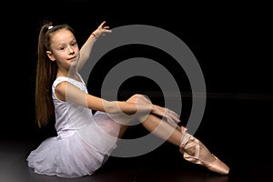 Beautiful little ballerina on a black background. dance concept.