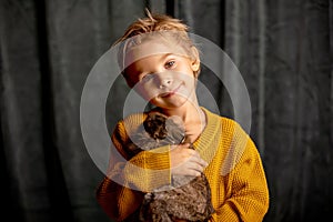 Beautiful little blond child, cute boy, holding small pet rabbit