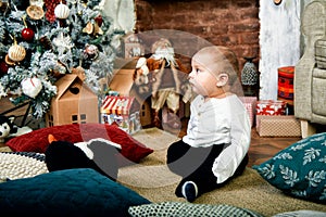 Beautiful little boy dreaming of cottages under the Christmas tree. Christmas concept and children waiting for a miracle