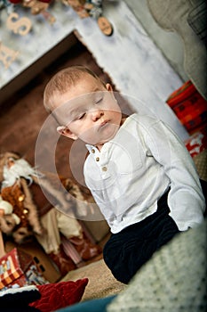 Beautiful little boy dreaming of cottages under the Christmas tree. Christmas concept and children waiting for a miracle