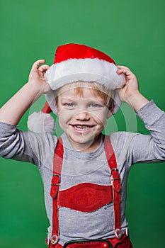 Beautiful little boy dressed like Santa Claus helper. Christmas concept