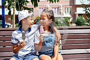 beautiful little boy and girl eating ice cream in summer