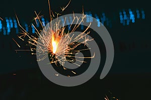 Beautiful little candle fireworks in glass bottle,hand holding sparkler on black background