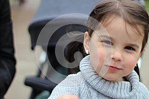 beautiful little cheerful smiling girl with her mother on a walk in the street