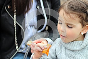 beautiful little cheerful smiling girl with her mother on a walk in the street