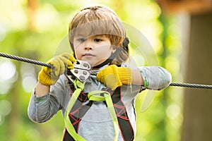 Beautiful little child climbing and having fun in adventure Park. Eco Resort Activities. Cute baby boy playing. Hike and