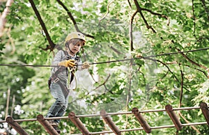 Beautiful little child climbing and having fun in adventure Park. Toddler kindergarten. Children summer activities