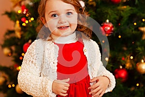 Beautiful little child near Christmas tree