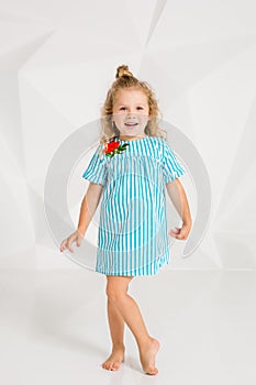 Beautiful little fashion model on white studio background. Portrait of cute girl posing in studio