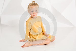 Beautiful little fashion model on white studio background. Portrait of cute girl posing in studio