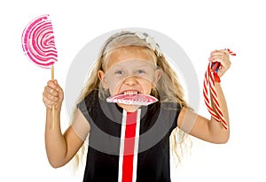 Beautiful little female child with sweet blue eyes and long blond hair eating huge lollipop spiral candy