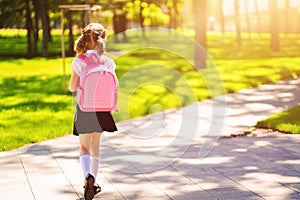 Beautiful little girl with backpack walking in the park ready back to school, back view, fall outdoors, education