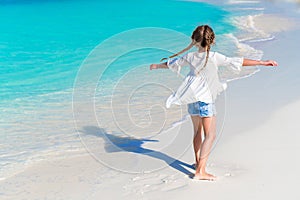 Beautiful little girl on the beach having fun. Funny girl enjoy summer vacation.