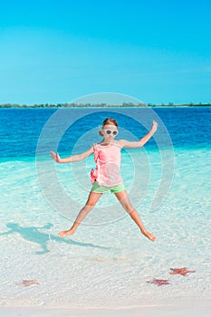 Beautiful little girl at beach having fun. Funny girl enjoy summer vacation.