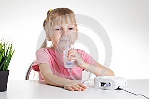 Beautiful little girl breathing into an inhaler for asthma and pneumonia at home. Treatment of diseases of the upper respiratory